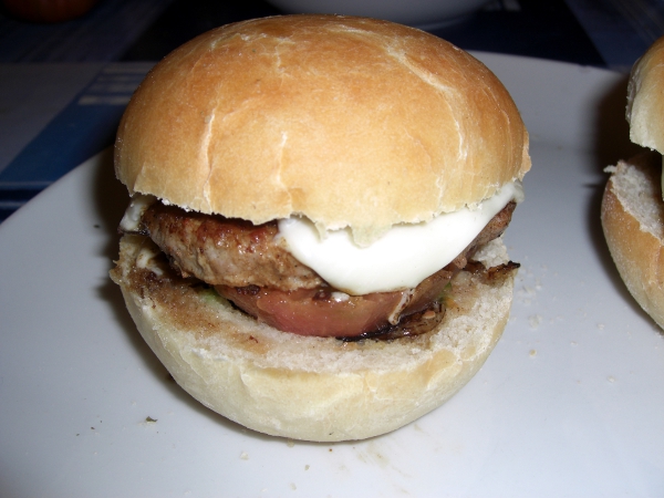 Hamburguesa de cerdo con cebolla, tomate, queso y bacón.