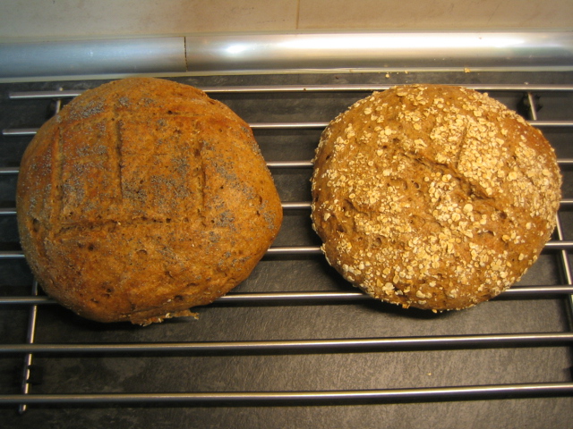 Los panes recién sacados del horno. El de la izquierda lleva espolvoreadas semillas de amapola y el de la derecha copos de avena. Por lo demás, idénticos.